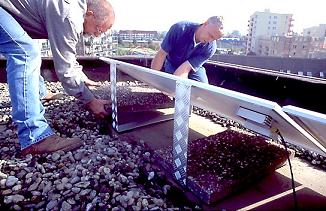 Installateurs zijn bezig om de zonnepanelen op het dak te installeren.