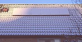 Dutch PV-system near coast (Leiden) on slanted roof covered with snow with temperature below 0 ºC and shading of nearby block of houses in heart of winter.