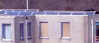 PV-system of 10 solar panels (1020 Wp), 6 on front row and 4 on back row on flat roof above 4th floor (telephoto)