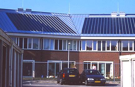 South-facing gable (garden side) of new sustainable housing project "de Oranjerie" in Leiden. Amorphous silicium solar panel strips on metal roof and solar collectors near ridge.